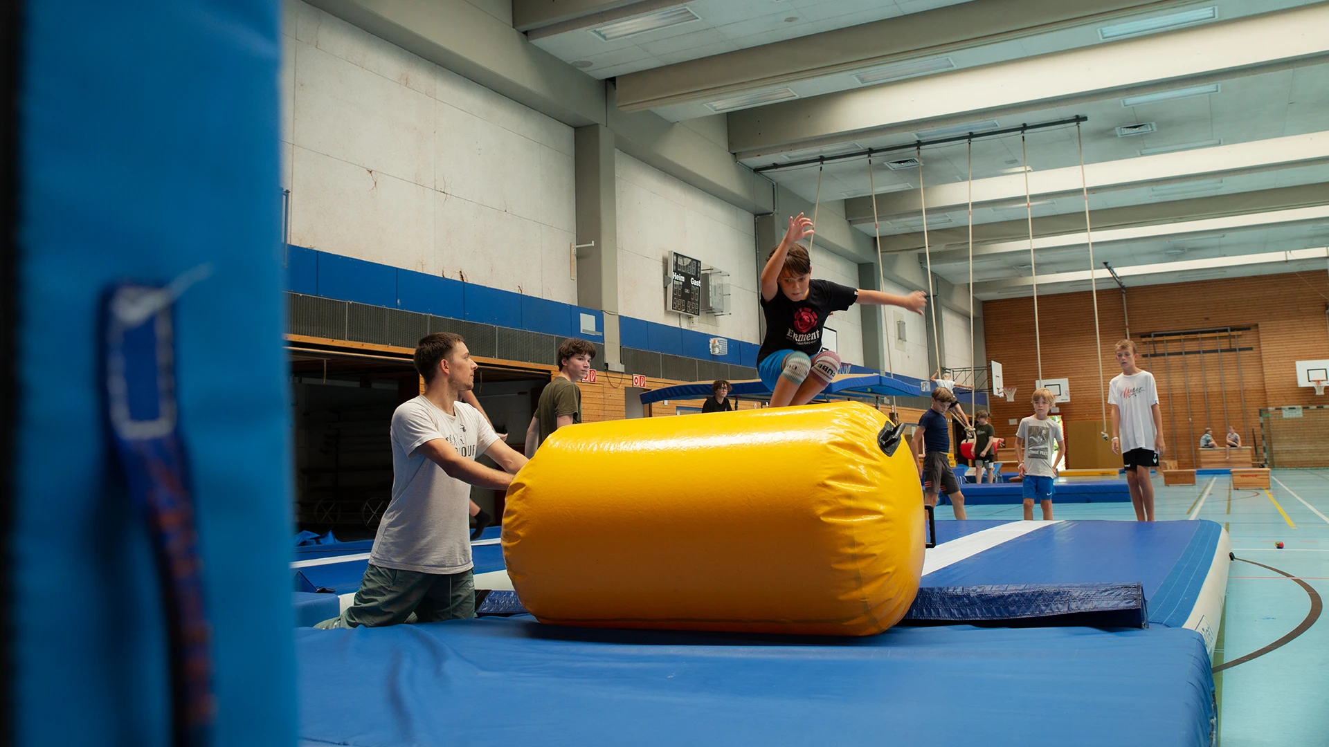Sprung über die Airtrack-Rolle in der Halle